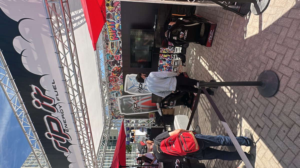 Guests queueing at a branded outdoor racing simulator event