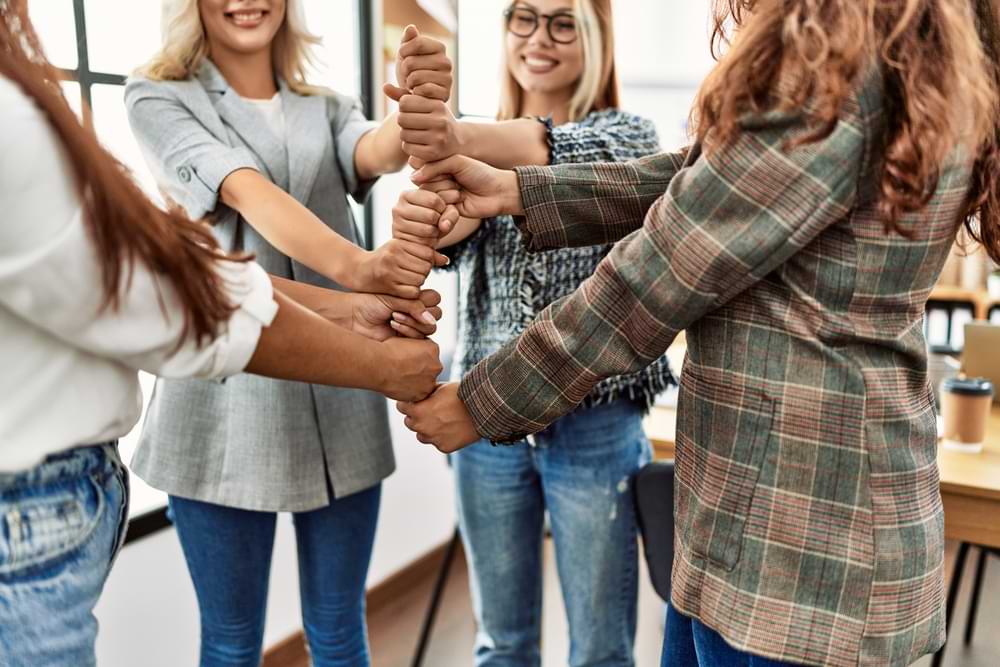Office workers holding their hands together