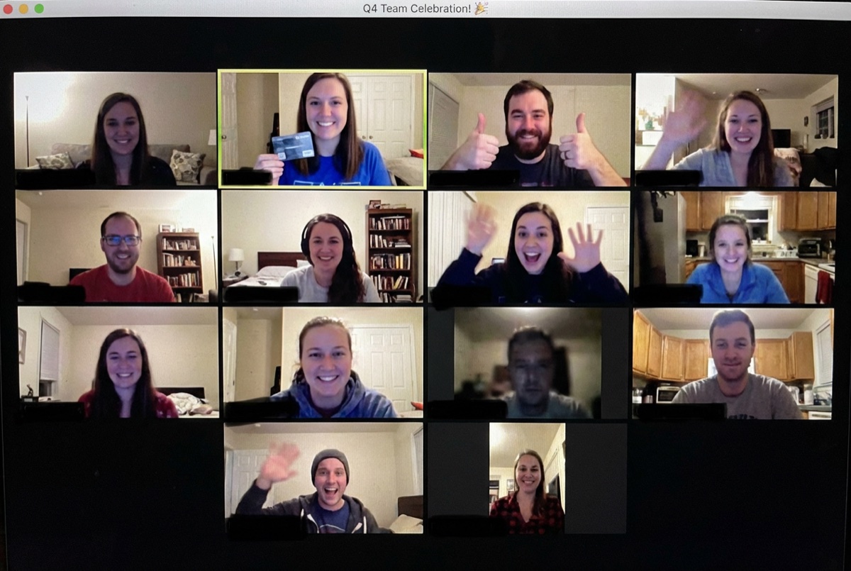Remote team celebrating quarterly win on video conference with gift card presentation